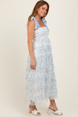 woman wearing a blue and white floral midi dress with ruffled straps and a smocked bodice, posing sideways