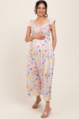 woman wearing a white floral print maternity dress with flutter sleeves and a visible baby bump