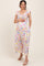 woman wearing a white floral print maternity dress with flutter sleeves and a visible baby bump