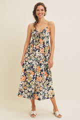 woman wearing a navy floral maxi dress with spaghetti straps and a tied front detail