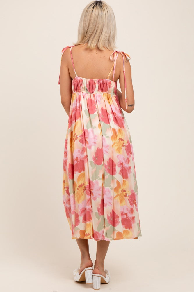 woman wearing a floral print maternity maxi dress with adjustable tie straps and an elastic waistband