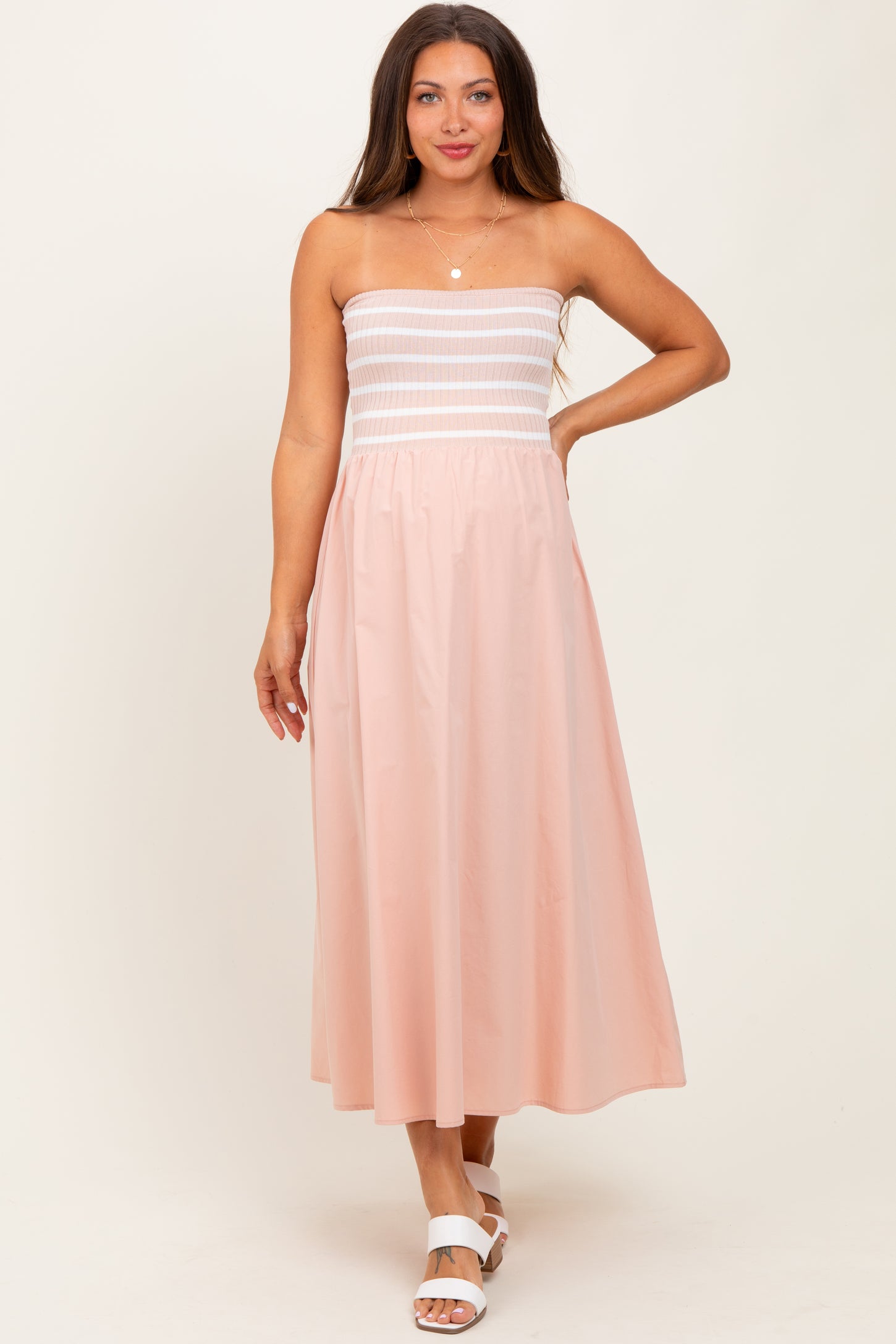 woman wearing a strapless pink maternity maxi dress with a fitted bodice and flowy skirt