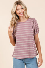 woman wearing a mauve and cream striped short sleeve top with puff sleeves, smiling and touching her hair