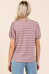 woman wearing a pink and white striped short sleeve top with puff sleeves and a keyhole back detail