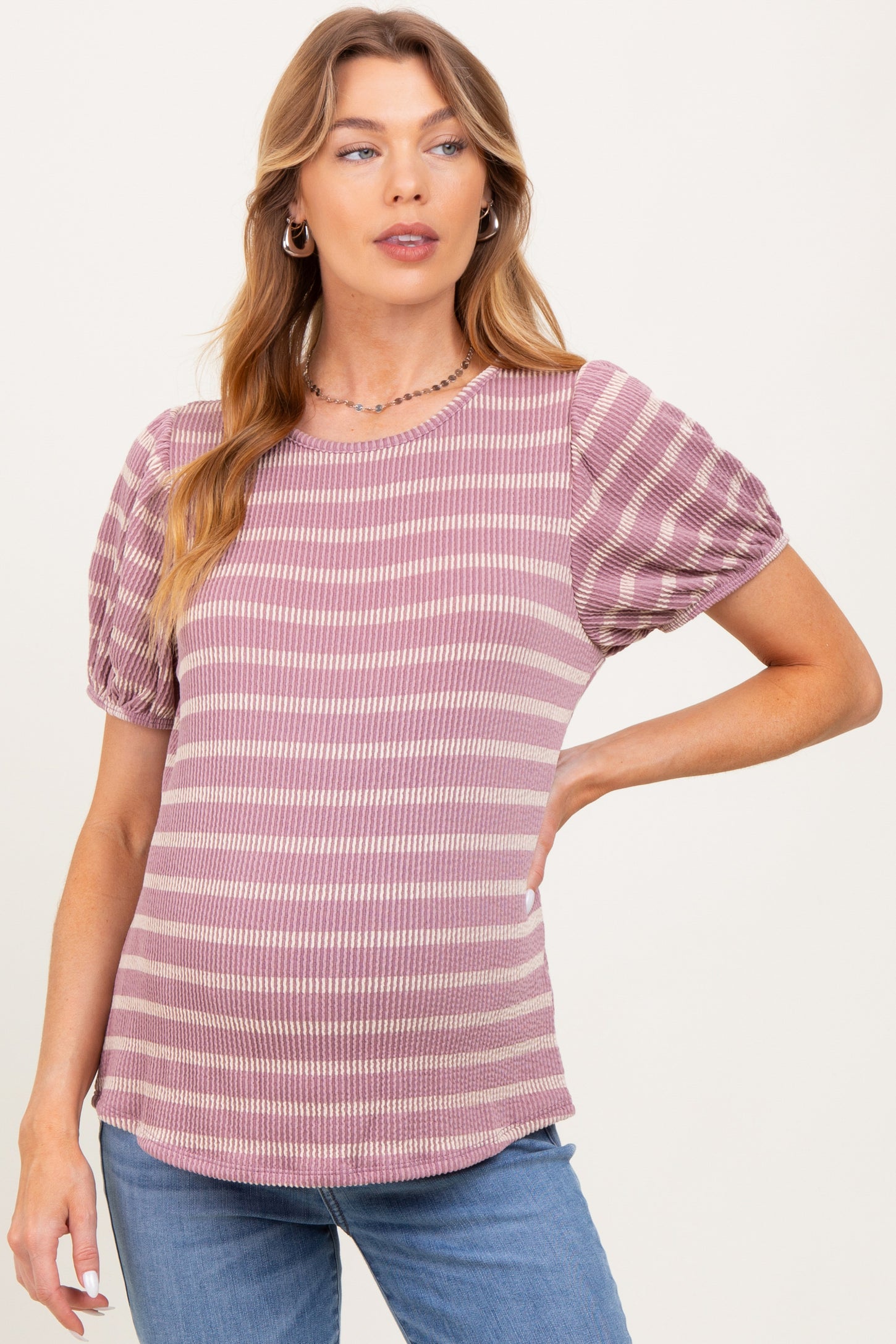 woman wearing a striped short sleeve maternity top with pleated sleeves and a visible baby bump