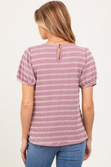 woman wearing a striped mauve maternity top with puff sleeves and a keyhole back detail