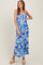 woman wearing a blue floral maxi dress with a deep V-neckline and spaghetti straps