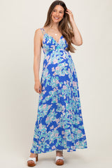 woman wearing a blue floral maternity maxi dress with a v-neckline and spaghetti straps, showcasing her baby bump