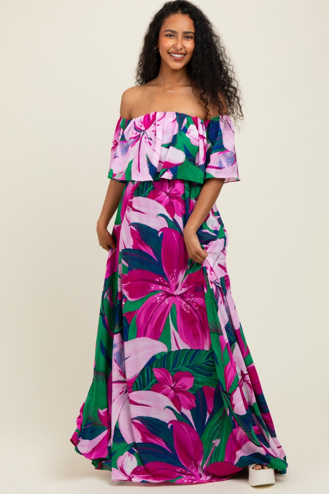 woman wearing a colorful off-the-shoulder maxi dress with large floral prints in pink and green