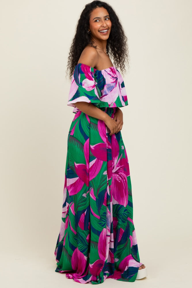 woman wearing a colorful off-the-shoulder maxi dress with a floral print in pink and green