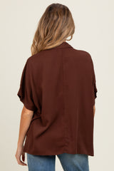woman wearing a brown maternity blouse with a relaxed fit and short sleeves, shown from the back