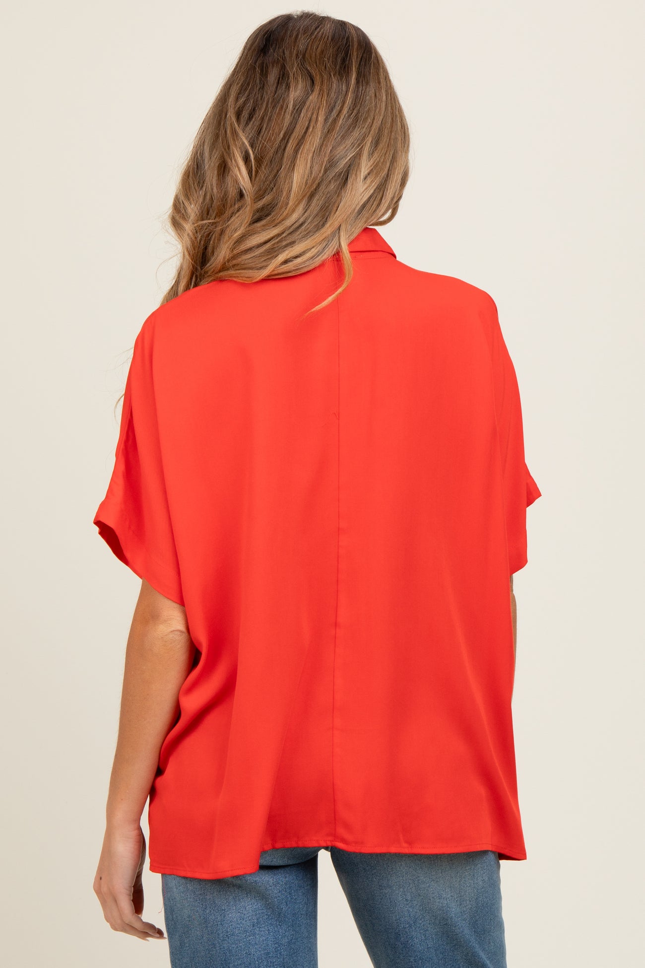 woman wearing a red short sleeve maternity blouse from the back