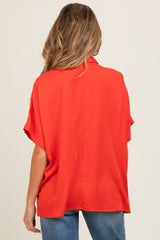 woman wearing a red short sleeve maternity blouse from the back