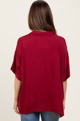 woman wearing a burgundy short sleeve maternity top, shown from the back with a relaxed fit