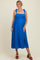 woman wearing a bright blue ruffle strap maternity dress with a button detail and a side split, showcasing her baby bump