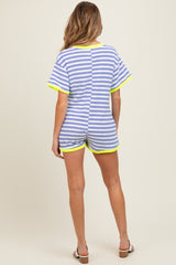 woman wearing a striped blue and white maternity romper with neon yellow trim, showing the back view