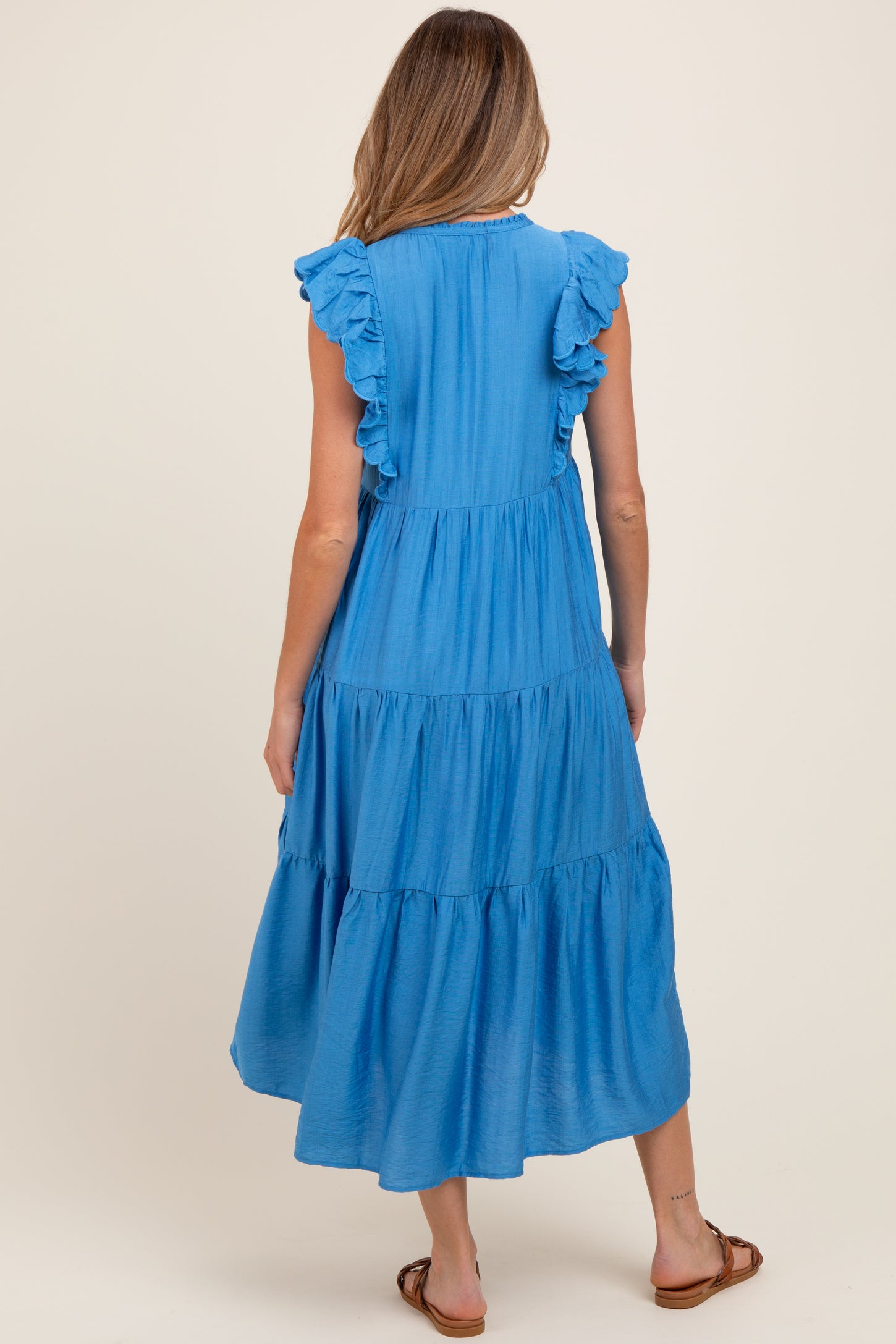 woman wearing a blue ruffle sleeve maternity maxi dress, seen from the back