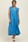 woman wearing a blue tiered midi dress with ruffle sleeves and a v-neckline, standing against a neutral background