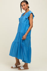 woman wearing a blue tiered maxi dress with ruffle sleeves and a flowy silhouette