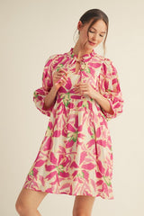 woman wearing a pink floral print balloon sleeve dress with a keyhole neckline and a relaxed fit