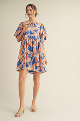 woman wearing a blue floral puff sleeve mini dress with a ruffled hem and cinched neckline