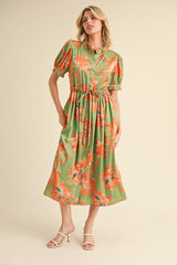 woman wearing a green floral midi dress with puff sleeves and a tie waist detail