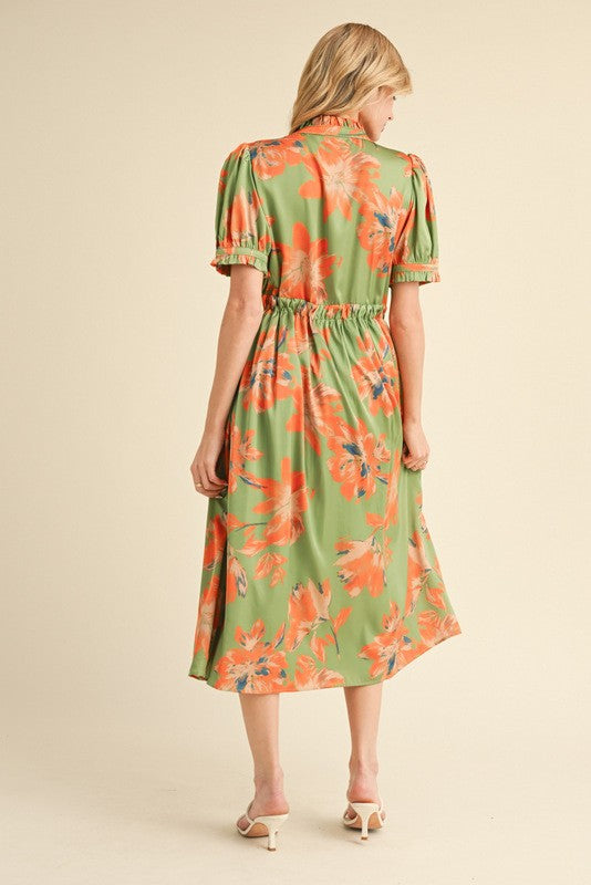 woman wearing a green floral midi dress with puff sleeves and a cinched waist, seen from the back