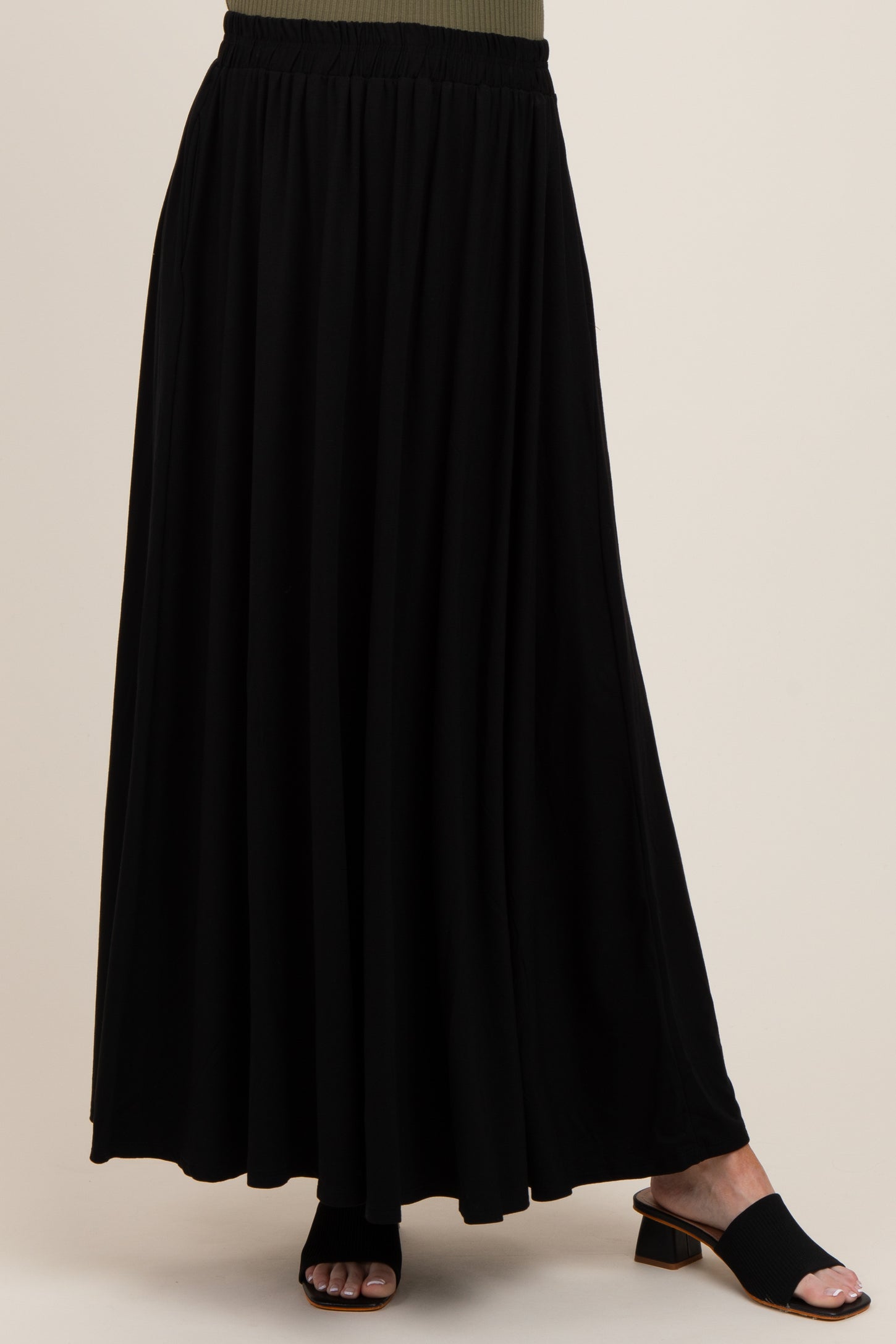 woman wearing a black maternity maxi skirt with a comfortable elastic waistband and flowy silhouette