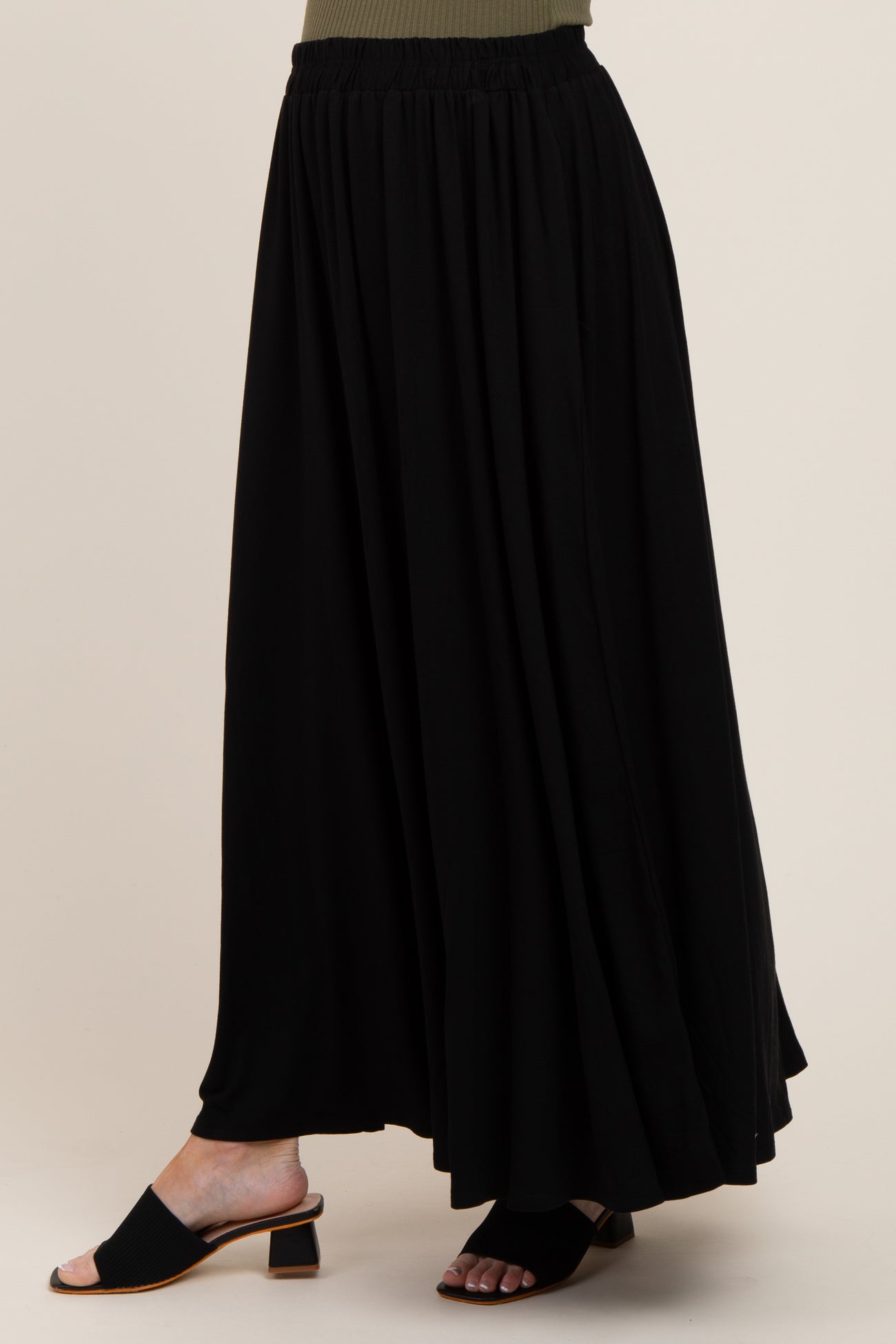 maternity wear long black maxi skirt with an elastic waistband, styled with a fitted top and black slide sandals