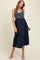 woman wearing a navy blue and white striped maternity dress with a flowing skirt and adjustable straps