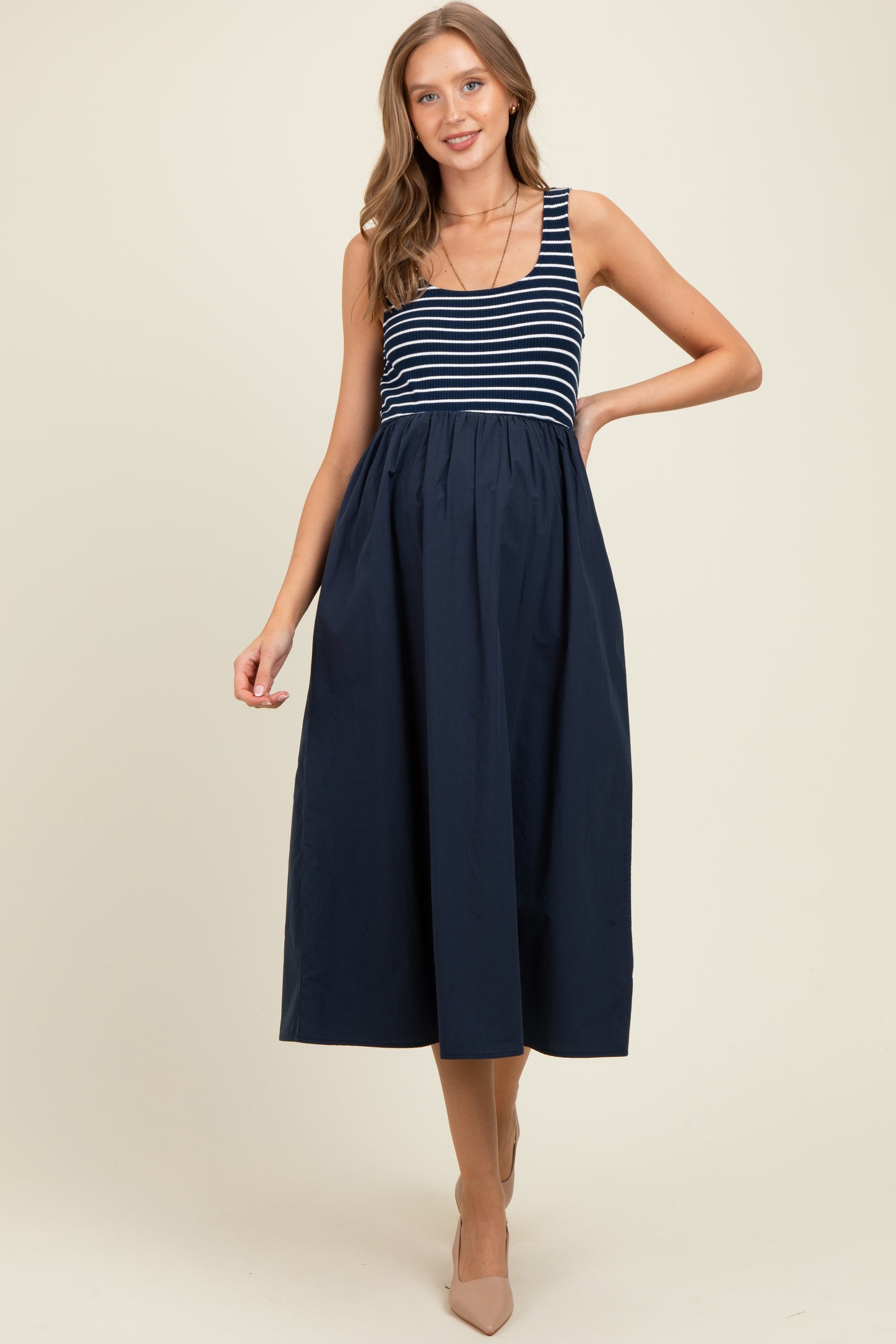woman wearing a navy blue and white striped maternity dress with a flared skirt and a fitted bodice