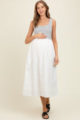 woman wearing a black and white striped maternity dress with a flowy white skirt, holding her baby bump