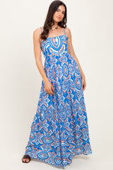 woman wearing a blue sleeveless maxi dress with a colorful abstract print