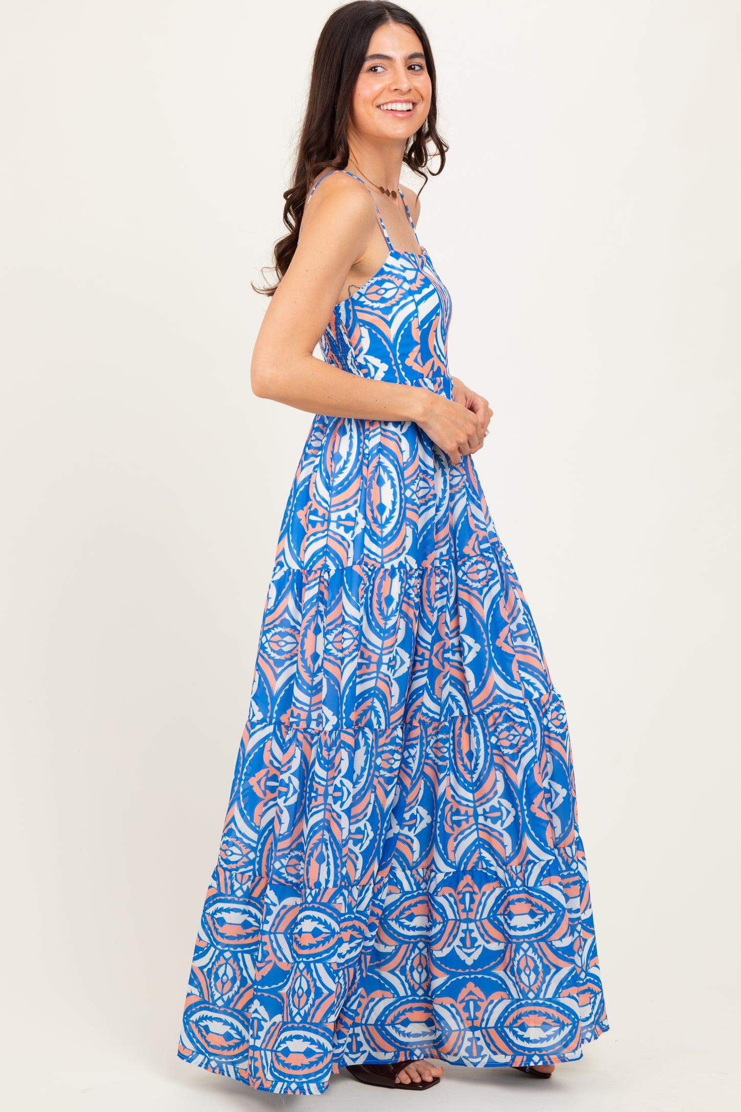 woman wearing a blue patterned maxi dress with spaghetti straps and a flowing skirt