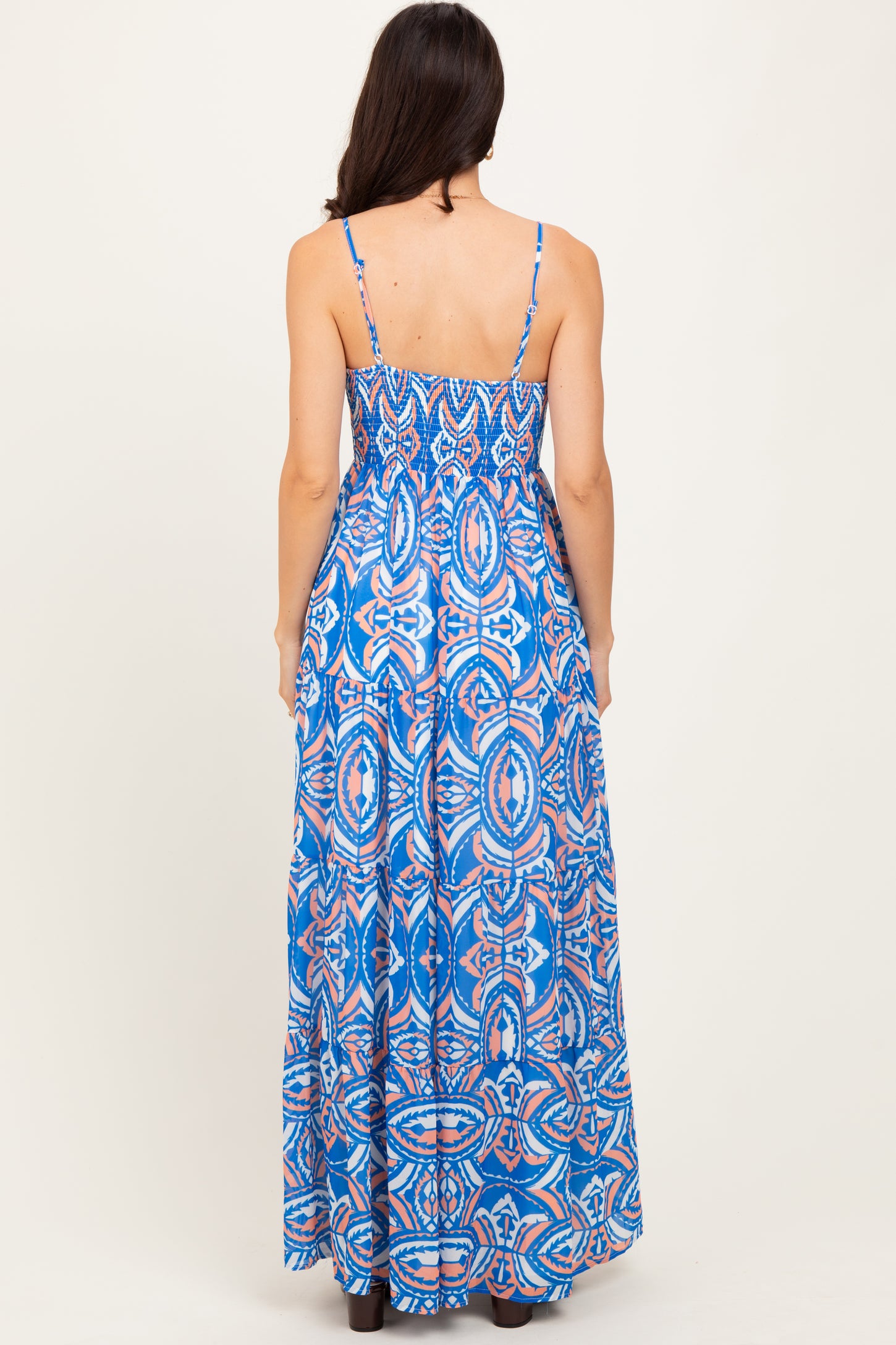 woman wearing a blue patterned maxi dress with spaghetti straps, viewed from the back