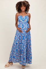 woman wearing a blue patterned maternity maxi dress and holding her baby bump
