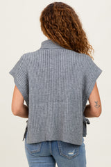 woman wearing a gray ribbed sweater top with short sleeves and open sides, seen from the back