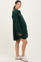 woman wearing a green corduroy maternity shirt dress with a visible baby bump and white sneakers
