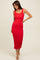 woman wearing a fitted red midi dress with a scoop neckline and ribbed texture, posing with her hand on her hip