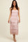 woman wearing a light pink maxi dress with textured stripes and a scoop neckline