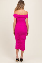 woman wearing a hot pink off-the-shoulder maternity dress with ruching details, showing a fitted silhouette from the back