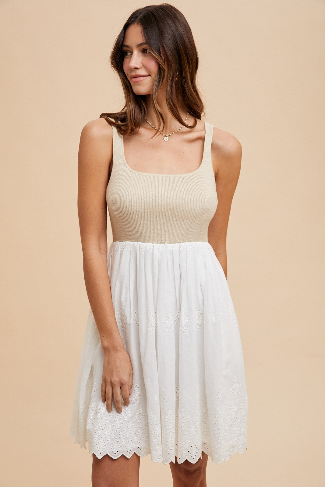 woman wearing a beige knit bodice and white embroidered skater dress