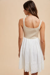 woman wearing a beige knit bodice and white eyelet sundress, seen from the back
