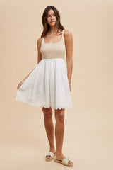 woman wearing a beige knit bodice sundress with a white embroidered skirt and white sandals