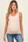 woman wearing a blush ribbed maternity tank top with scalloped neckline and visible baby bump