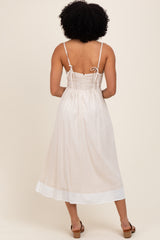 woman wearing a back view of a light beige sundress with a smocked bodice and adjustable straps