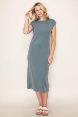 woman wearing a gray cap sleeve midi dress and posing with one hand in her hair