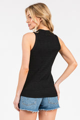 woman wearing a black sleeveless top with ruching at the back paired with denim shorts