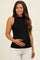 woman wearing a black sleeveless maternity top and holding her baby bump