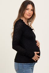 woman wearing a black long sleeve maternity top and holding her baby bump